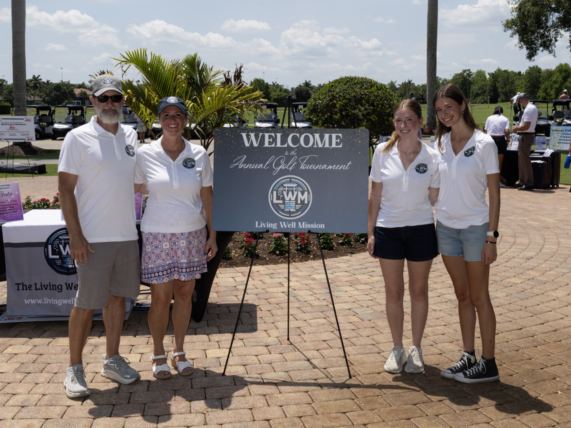 The Living Well Mission team beside the tournament welcome sign