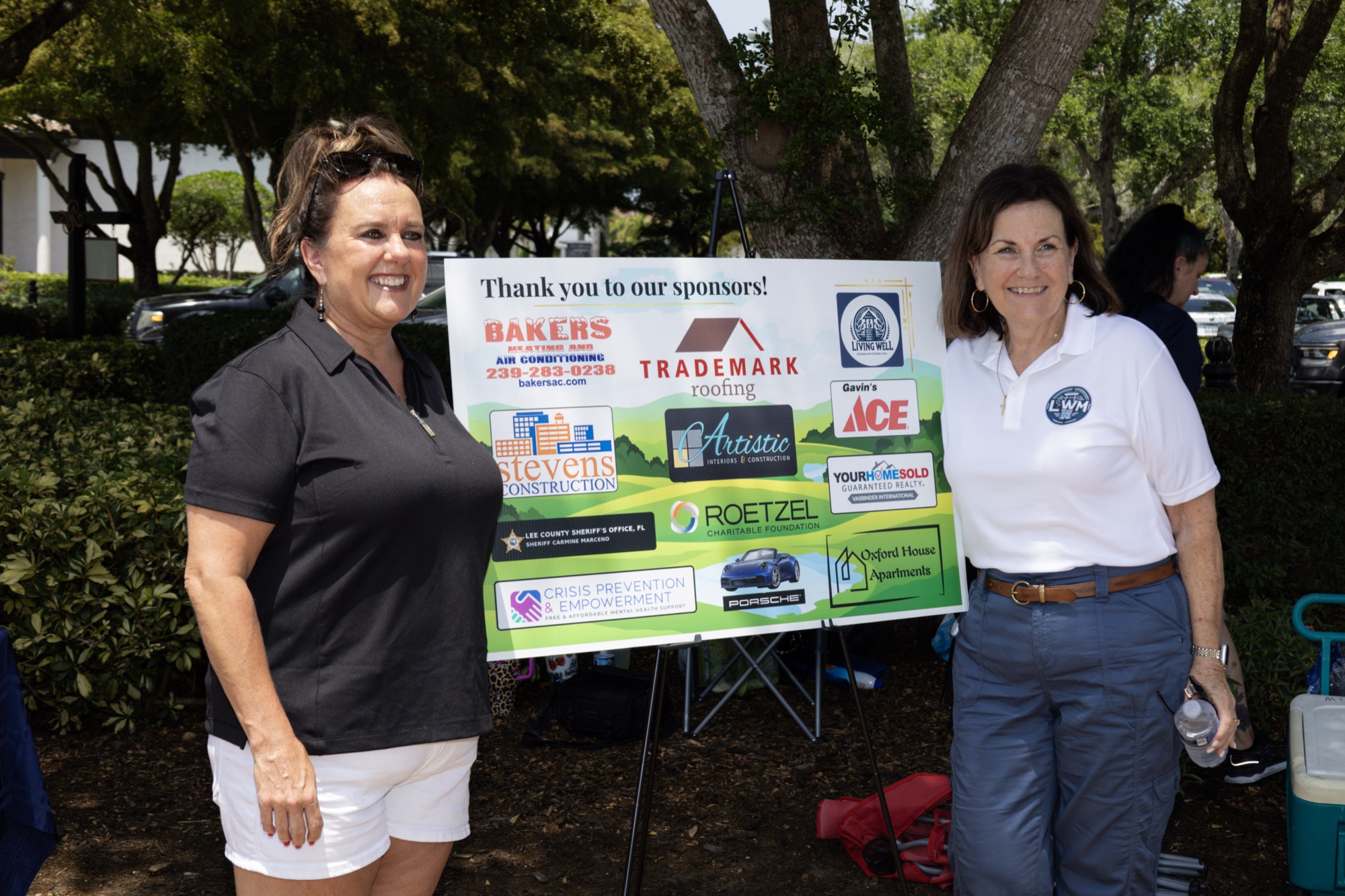 Supporters beside the sponsor thank-you board