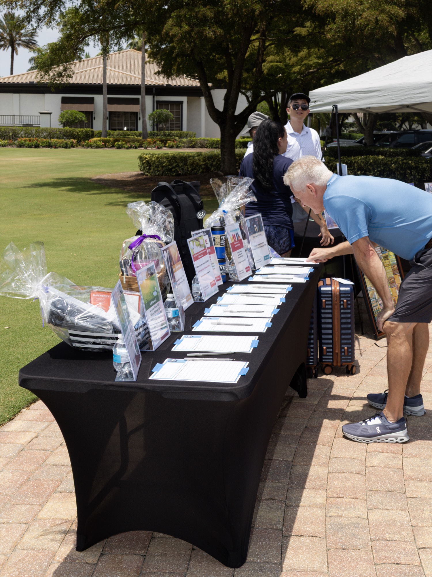 Silent auction and raffle table lined with gift baskets at the tournament