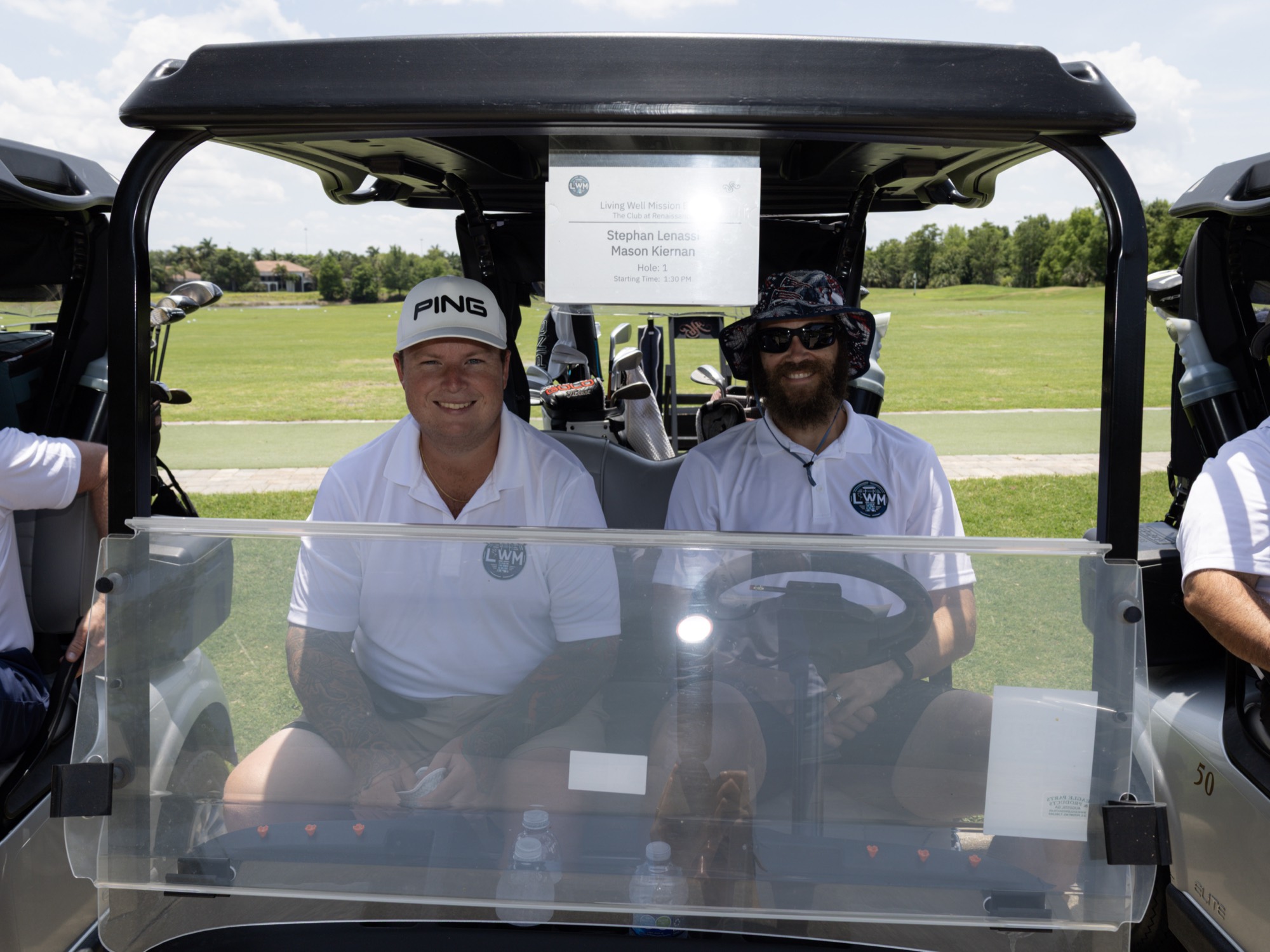 A smiling foursome ready to roll out in their golf cart