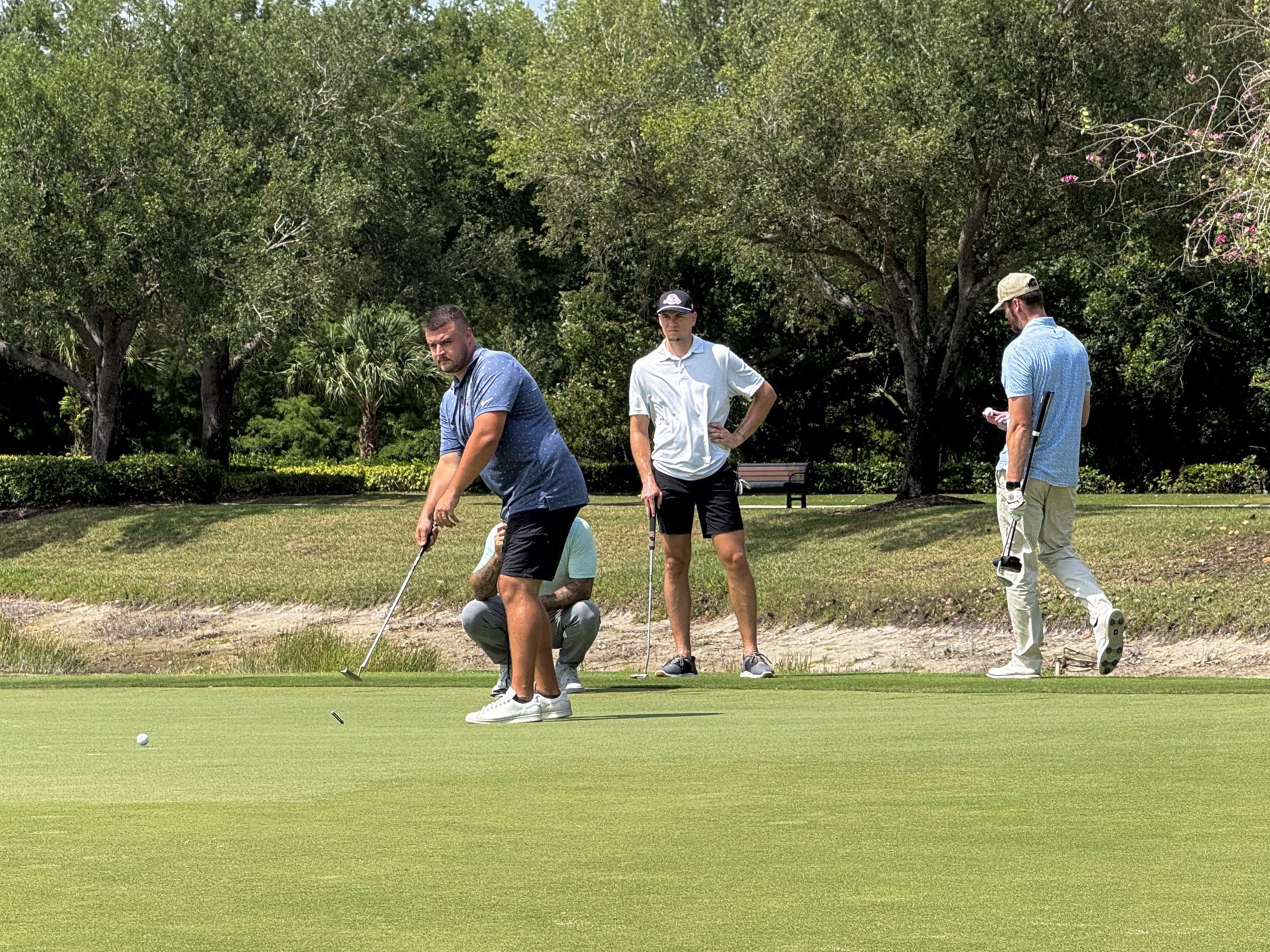 Players reading a putt on the green